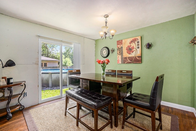 dining room with hardwood / wood-style floors and a notable chandelier