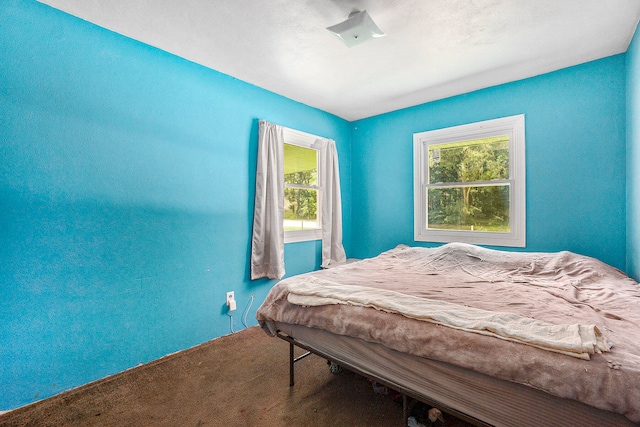 carpeted bedroom featuring multiple windows