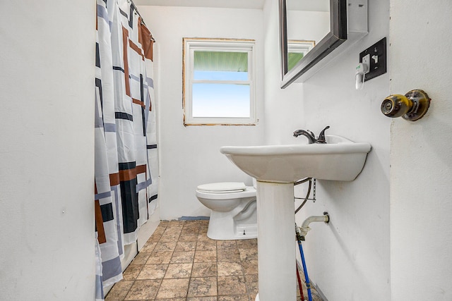 bathroom featuring a shower with curtain and toilet