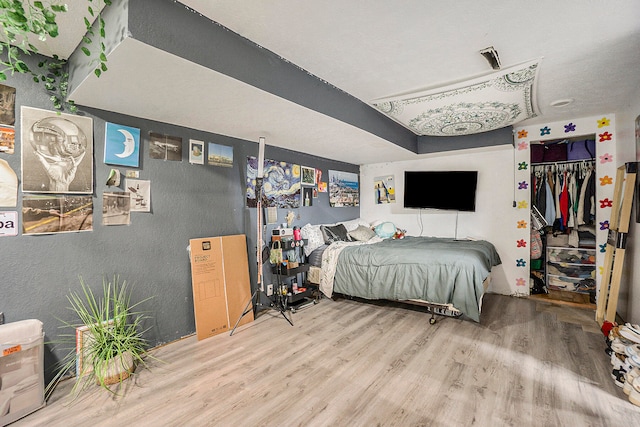 bedroom with a closet and hardwood / wood-style floors