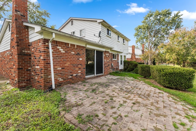 18230 Rainbow Dr, Lathrup Village, MI 48076 - back of property featuring a chimney, brick siding, and a patio area
