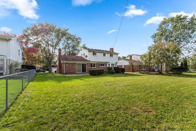 rear view of house featuring a yard