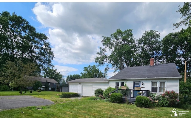 view of front of property with a wooden deck, a front yard, and a garage