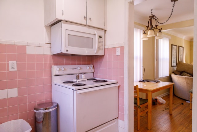 kitchen with tile walls, white cabinets, light hardwood / wood-style floors, and white appliances