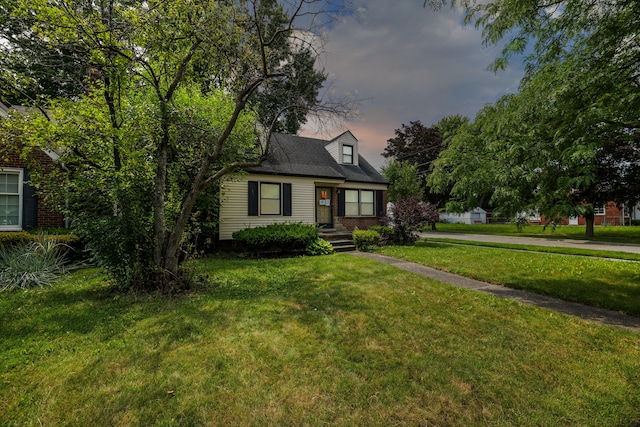 cape cod-style house with a lawn