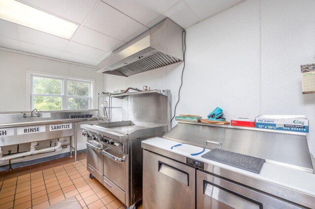 18564 200th, Tustin, MI 49688 - kitchen featuring wall chimney range hood, double oven range, a paneled ceiling, light tile patterned floors, and light countertops