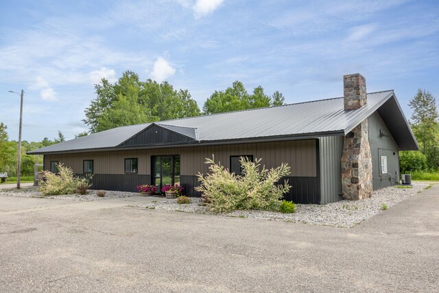 18564 200th, Tustin, MI 49688 - view of front facade featuring a chimney, metal roof, and central AC