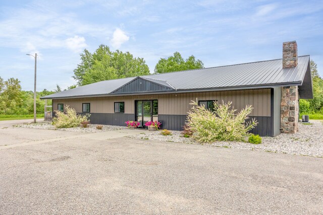 18564 200th, Tustin, MI 49688 - view of front of property with a chimney, metal roof, and cooling unit