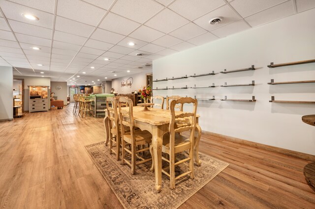 18564 200th, Tustin, MI 49688 - dining area with light wood-type flooring, baseboards, bar area, recessed lighting, and a paneled ceiling