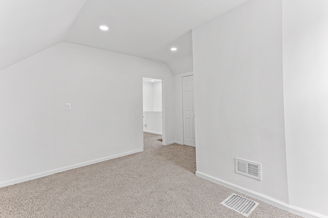 carpeted empty room with lofted ceiling