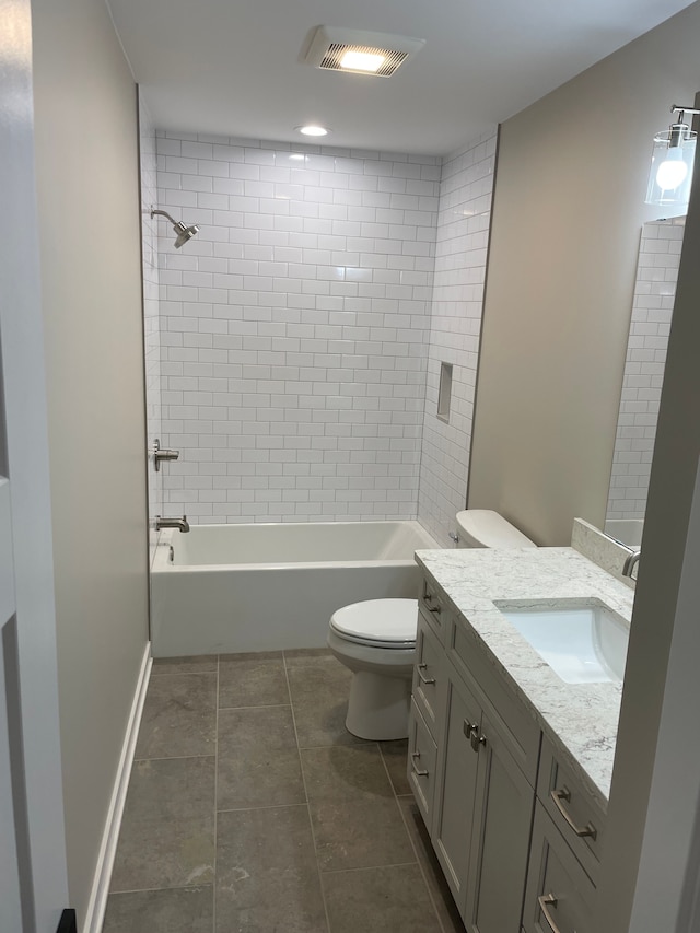 full bathroom featuring vanity, tiled shower / bath, tile patterned floors, and toilet