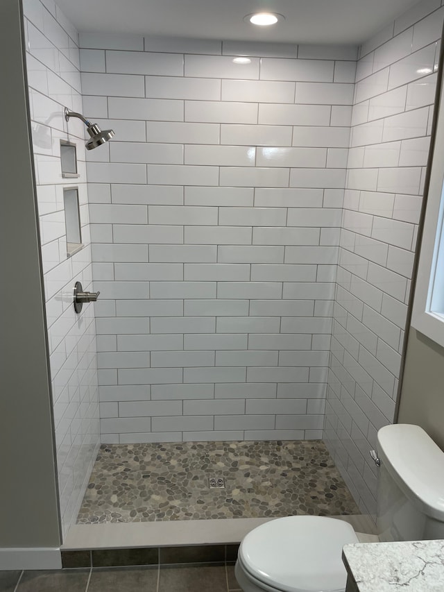 bathroom with tiled shower and toilet