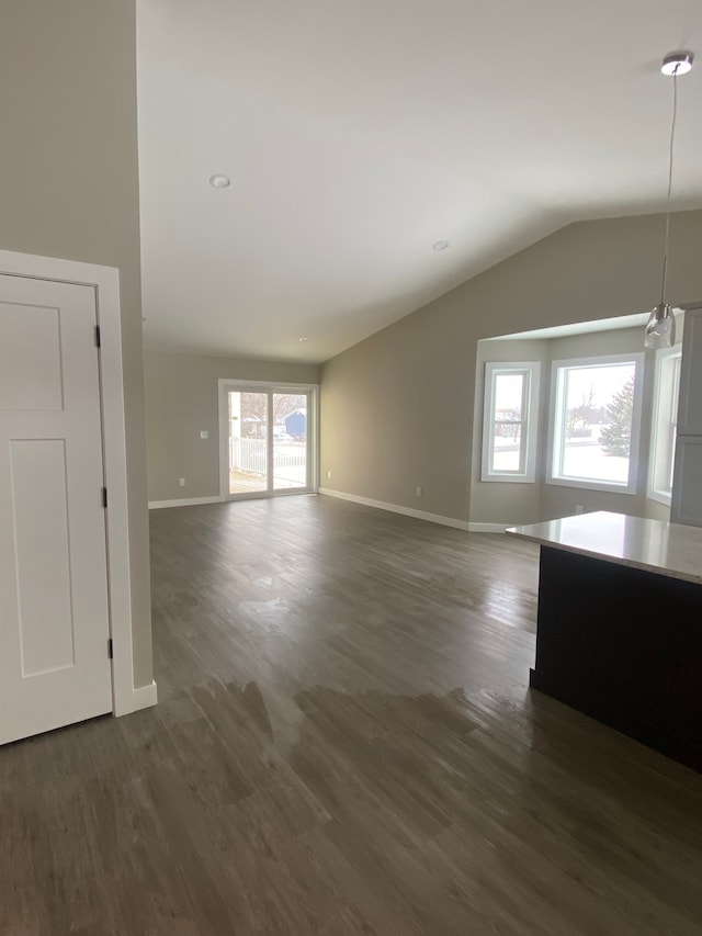 empty room featuring dark wood-type flooring and vaulted ceiling