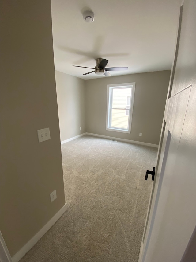 spare room featuring light colored carpet and ceiling fan