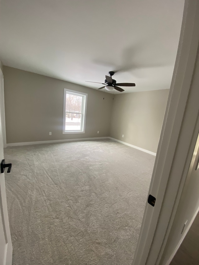 spare room featuring ceiling fan and carpet