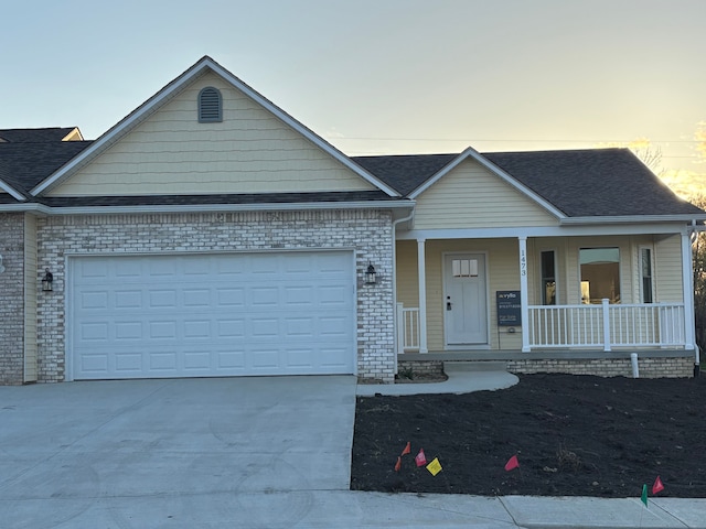 1473 Mallard Cir, Owosso, MI 48867 - view of front of property with a porch, concrete driveway, a garage, and roof with shingles