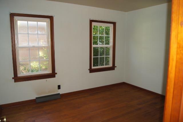 empty room with dark hardwood / wood-style flooring