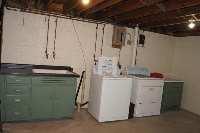 washroom with cabinets, electric panel, and washer and clothes dryer