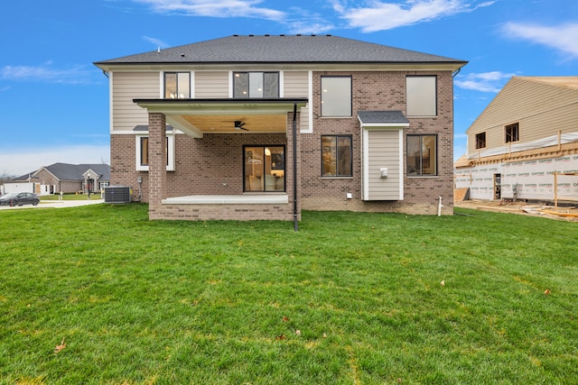 rear view of house featuring a lawn, ceiling fan, a patio area, and central air condition unit