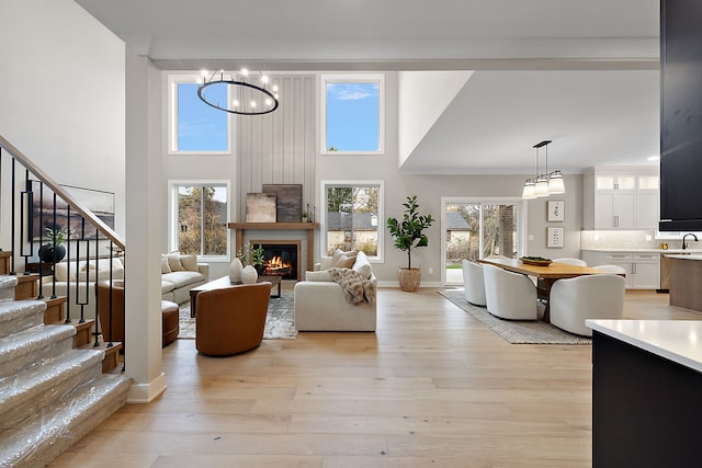 living room featuring plenty of natural light, a high ceiling, and light wood-type flooring