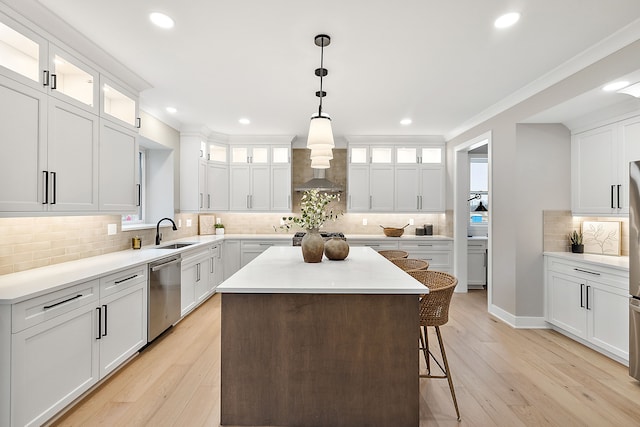 kitchen featuring stainless steel dishwasher, a kitchen island, white cabinets, and light wood-type flooring