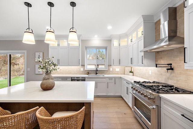 kitchen featuring white cabinets, stainless steel appliances, plenty of natural light, and wall chimney range hood