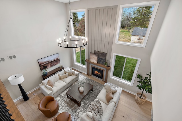 living room with light wood-type flooring and a chandelier