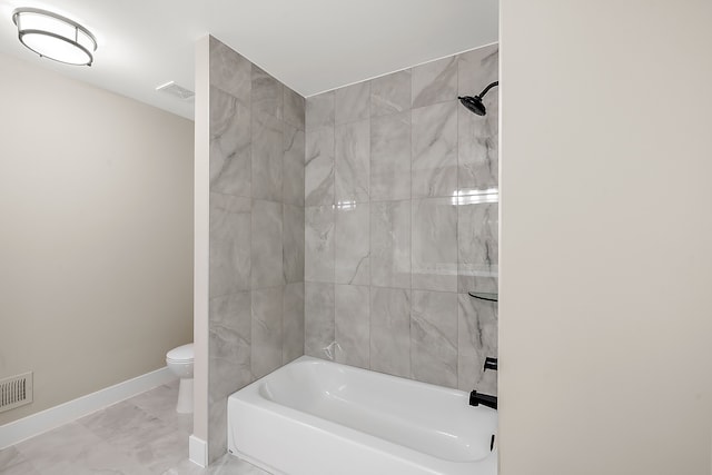 bathroom with tiled shower / bath combo and toilet