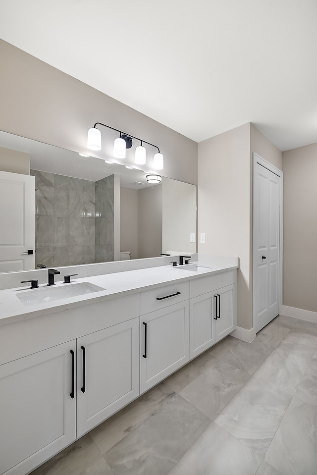 bathroom with a tile shower and vanity