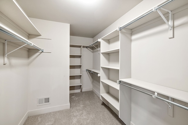 walk in closet featuring dark colored carpet