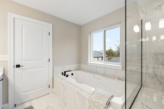 bathroom with vanity and tiled bath