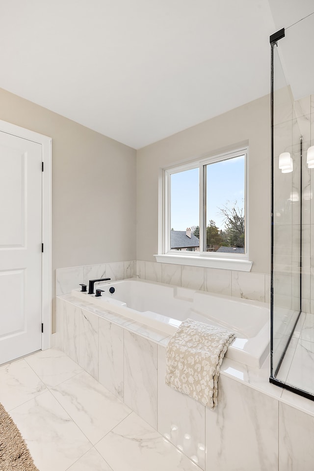 bathroom with a relaxing tiled tub