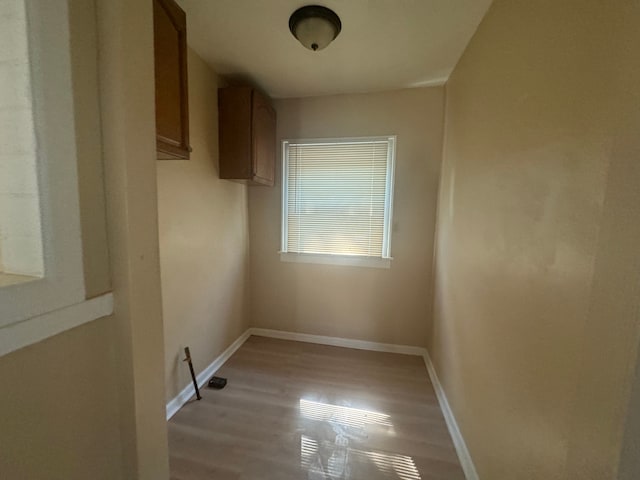 clothes washing area with light hardwood / wood-style flooring