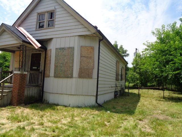 view of side of home with a yard