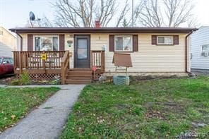 view of front facade with a deck and a front lawn