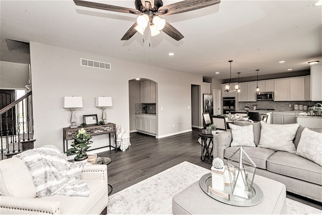 living room with dark hardwood / wood-style floors and ceiling fan