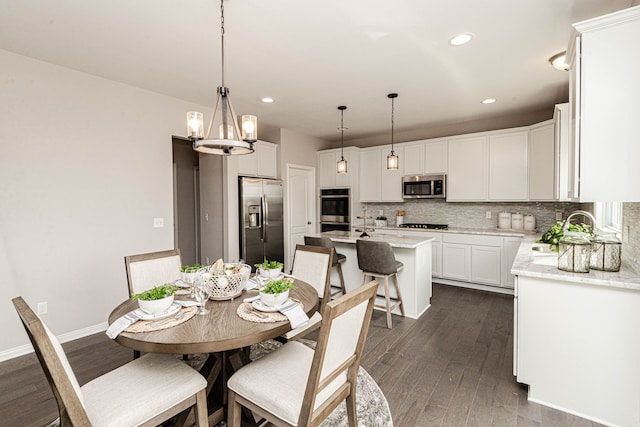 dining space with a chandelier, dark wood-type flooring, and sink