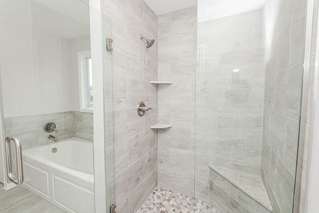 bathroom featuring shower with separate bathtub