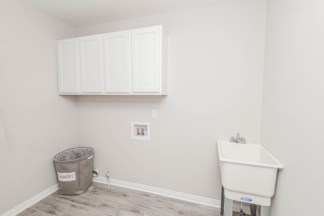 clothes washing area featuring washer hookup, gas dryer hookup, cabinets, and sink