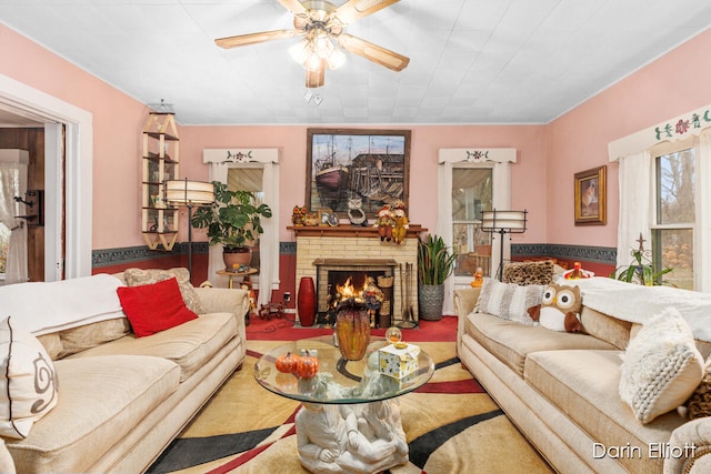 living room with a brick fireplace and a ceiling fan