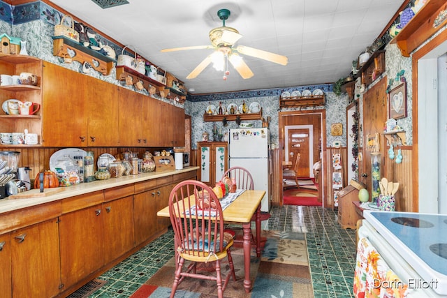 kitchen featuring dark floors, white appliances, brown cabinets, open shelves, and wallpapered walls