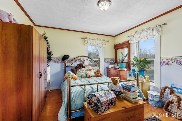 bedroom with a textured ceiling, wood finished floors, and crown molding