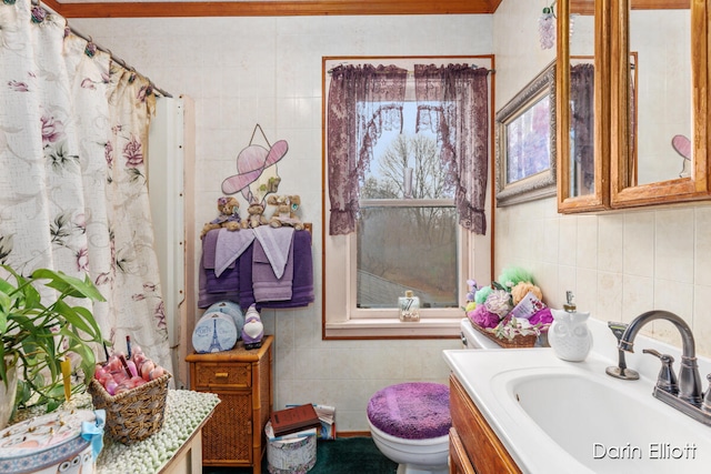 full bathroom with toilet, vanity, and tile walls