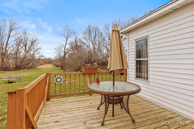 wooden deck featuring a lawn