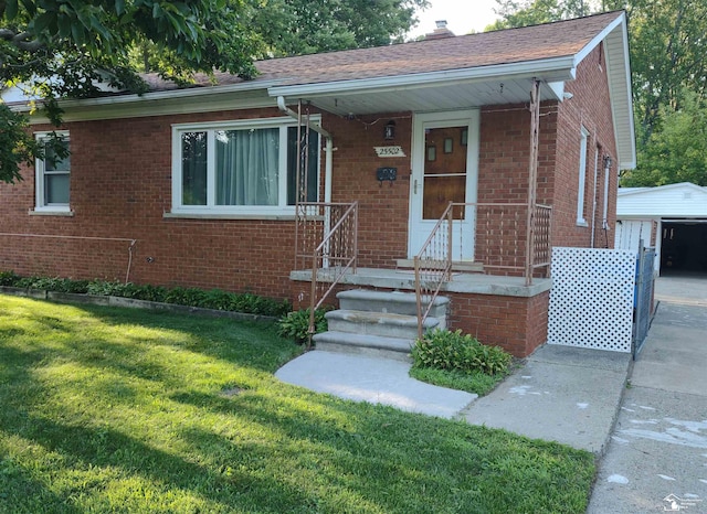 bungalow featuring a garage, an outdoor structure, and a front lawn