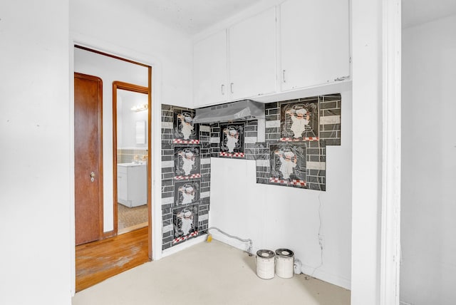 kitchen featuring white cabinets and washer / dryer