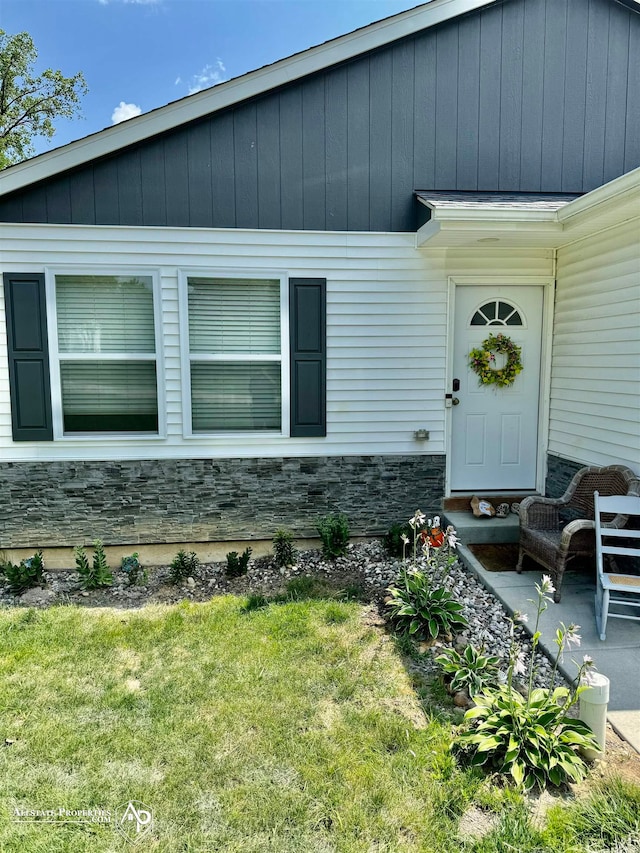 property entrance featuring a lawn