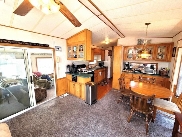 831 S Main St, Au Gres, MI 48703 - dining area with dark colored carpet, wainscoting, wood walls, and ceiling fan