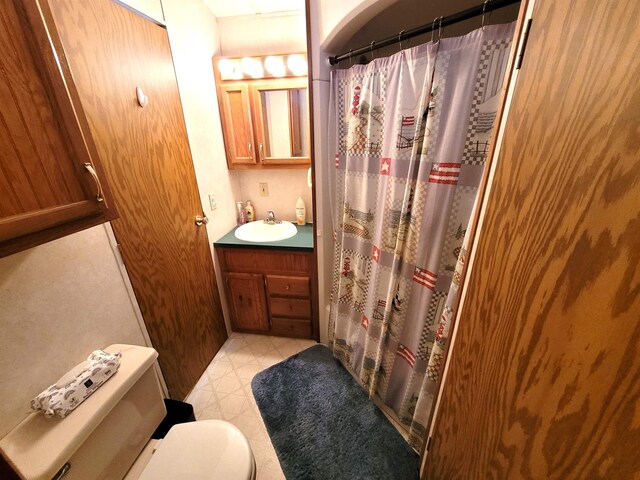 831 S Main St, Au Gres, MI 48703 - bathroom featuring vanity, toilet, a shower with shower curtain, and tile patterned floors