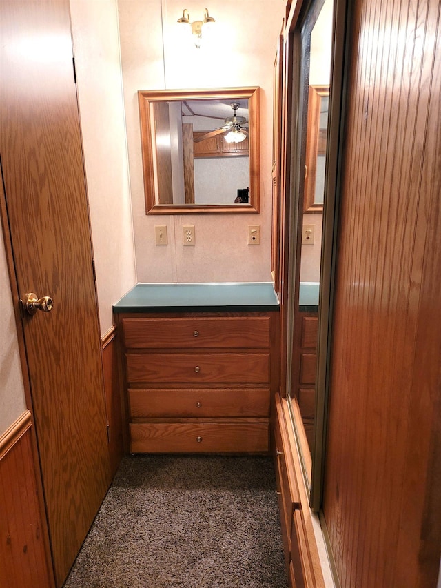 831 S Main St, Au Gres, MI 48703 - bathroom with vanity, a wainscoted wall, wood walls, and ceiling fan